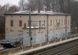 Der Friesacker Bahnhof liegt einige Kilometer nördlich der Stadt mitten im Havelländischen Luch. In früheren Zeiten gab es bisweilen heftigen Streit darüber, ob die Bahn das Monopol über Kutschfahrten für Reisende nach Friesack beanspruchen dürfe, oder nicht. 